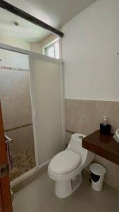 een badkamer met een wit toilet en een douche bij SUIT HOME EXPRESs in Cancun