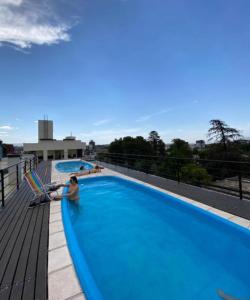 two people sitting in a swimming pool on top of a building at Depto Centrico Exclusivo in Villa Carlos Paz