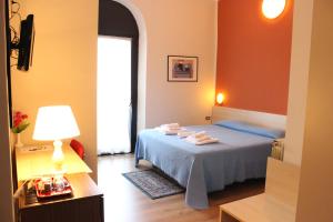 a bedroom with a bed and a lamp and a window at Hotel Europa in Sesto San Giovanni +37 photos