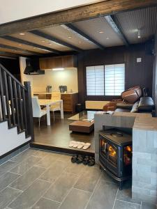 a living room with a couch and a stove at furano Hokuseisanso I in Furano