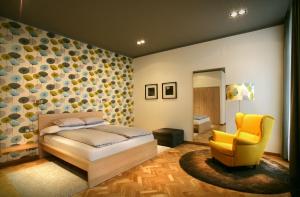 sypialnia z łóżkiem i żółtym krzesłem w obiekcie Gateway Budapest City Center w Budapeszcie