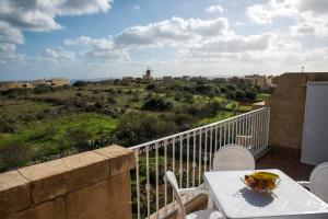 einen Tisch mit einer Obstschale auf dem Balkon in der Unterkunft GozoPride Penthouse in Qala