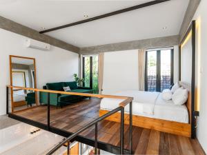 a room with a bed and a glass railing at Berawa Lofts #2 Canggu in Canggu