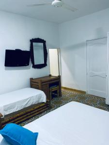 a room with two beds and a mirror and a table at Habitaciones independientes con baño privado #6 in Cartagena de Indias