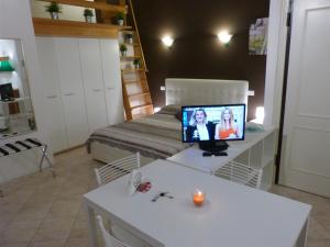 ボローニャにあるResidenza Galvaniのベッド1台、テレビ、テーブルが備わる客室です。