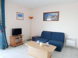 a living room with a blue couch and a table at Etel: Appartement 3 pièces, Vue Ria, Parking, Animaux admis - FR-1-479-167 in Étel