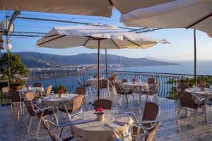 un restaurante con mesas y sillas con vistas al océano en Baia Serena, en Vico Equense