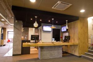 an office lobby with a reception desk and tv at ibis Chambery in Chambéry