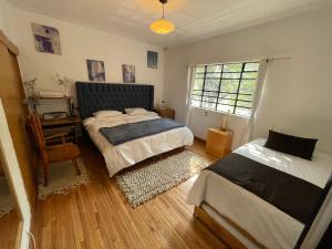 a bedroom with two beds and a desk and a window at Hostal Roma Condesa in Mexico City +68 photos