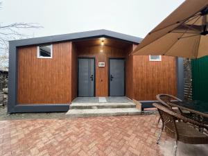 a building with two doors and a table and an umbrella at 51 guest house in Bishkek