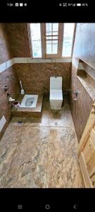 un ampio bagno con servizi igienici e lavandino di Mahima Guest House a Bodh Gaya