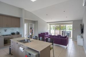 cocina y sala de estar con muebles de color púrpura. en Swan Lake View House, en Berrara