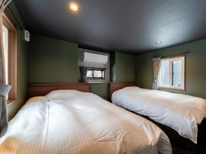 Postel nebo postele na pokoji v ubytování Myoko Onsen cottage Ajisai