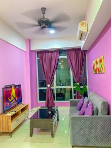 コタキナバルにあるSutera Avenue ira Kkinabalu Homestayのソファとテレビのあるリビングルーム