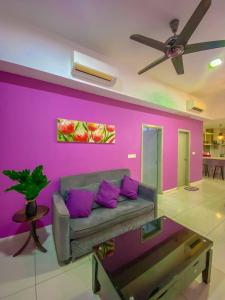 コタキナバルにあるSutera Avenue ira Kkinabalu Homestayの紫の壁のリビングルーム(ソファ付) +3枚の写真