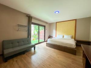ein Schlafzimmer mit einem Bett und einer Couch und einem Fenster in der Unterkunft Good Mood Resort in Ko Lipe + 70 Fotos