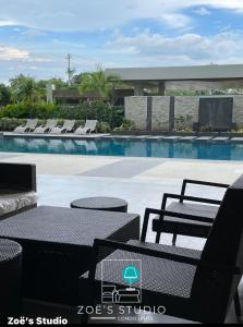 a swimming pool with tables and chairs next to a pool at Zoe Studio Mesavirre in Bacolod