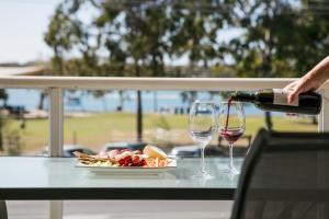 eine Person, die ein Glas Wein auf einen Tisch gießt in der Unterkunft Lazy Days by Stay Noosa in Noosaville