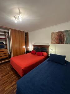 twee bedden in een kamer met rode en blauwe lakens bij Departamento Salta Nuevo Encuentro in Salta +62 foto's