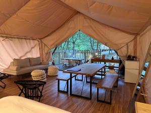 a tent with a table and chairs in it at Mieux Forest in Uenohara