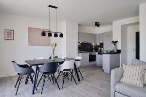 a kitchen and living room with a table and chairs at Maisonette-Apartment C11 Zwei Balkone, zwei Terrassen im "Pine Hill Resort" in Zirchow