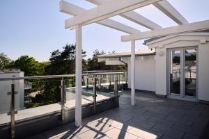 a deck with a pergola on a house at Maisonette-Apartment C11 Zwei Balkone, zwei Terrassen im "Pine Hill Resort" in Zirchow