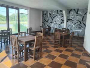 a restaurant with wooden tables and chairs on a checkered floor at La Playita in Monte Gordo