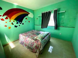 a bedroom with a rainbow and butterflies on the wall at Casa da Orla - Piscina, Churrasqueira, 4 minutos da Orla Pôr do Sol in Aracaju +38 photos