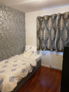 ein kleines Schlafzimmer mit einem Bett und einem Vorhang in der Unterkunft 3 bed Professional Suite for Long term in Aberdeen