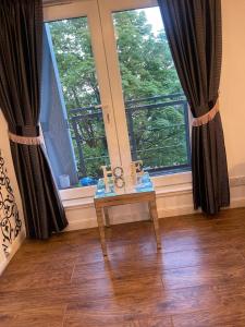 ein Raum mit einem Tisch und zwei großen Fenstern in der Unterkunft 3 bed Professional Suite for Long term in Aberdeen