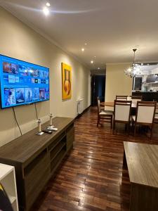 a living room with a large television and a dining room at Departamento Lindo Colonial Salta in Salta