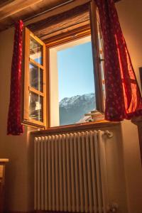 ein Fenster mit einem Heizkörper und einem schneebedeckten Berg in der Unterkunft Le Petit Fenestrelle in Fenestrelle