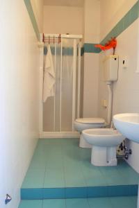 uma casa de banho com 2 WC e um chuveiro em Hotel Rex em Lido di Jesolo