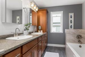a bathroom with two sinks and a large mirror at Goode Homes Luxury Family Home in Granada Hills +45 photos