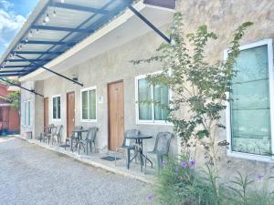a patio with chairs and a table and windows at บ้านหมอบิวรีสอร์ทเชียงคาน BaanmhorbiwResortChiangKhan in Chiang Khan