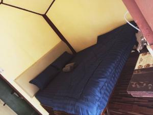 ein blaues Bett in einem Zimmer mit gelber Wand in der Unterkunft Ingdao Bungalow Koh Chang อิงดาว บังกะโล เกาะช้าง in Ko Chang