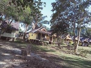 eine Gruppe von Hütten auf einem Feld mit Bäumen in der Unterkunft Ingdao Bungalow Koh Chang อิงดาว บังกะโล เกาะช้าง in Ko Chang