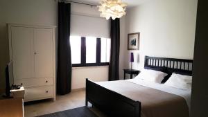 a bedroom with a large bed and a chandelier at Mazzara Farm in Manduria