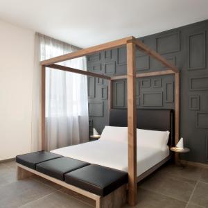 un letto con struttura in legno in una camera da letto di La Chambre Milano Guest House a Milano