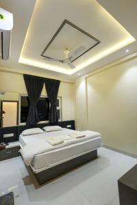 a bedroom with a bed with a ceiling fan at Nandini Executive Lodge in Tuljapur