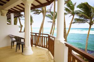 a porch with a view of the ocean with palm trees at Beach Inns Holiday Resort in Matara
