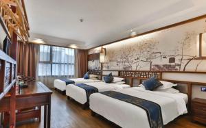 张家界Zhangjiajie Huan Sha Ju Hotel的墙上的一排床