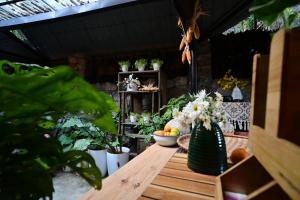 a wooden table with flowers and plants on it at Le Petit Home in Dồng Văn