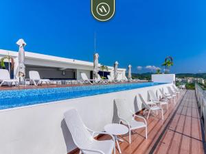 a row of white chairs and a swimming pool at Luxury Oceanfront 3 BR Condo - Private Jacuzzi in Cruz de Huanacaxtle