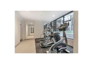 a gym with two treadmills and two ellipticals at Hot Deal! Sky Stars Central Haven Studio with nice pool In CBD heart in Auckland
