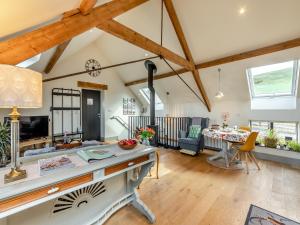 una sala de estar con techos de madera y una habitación con una mesa. en The Granary - Uk43356, en Branxton