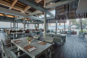 a restaurant with a table and chairs and a view of the ocean at Ramayana Candidasa Beach Resort in Candidasa