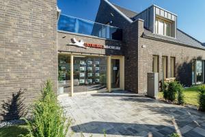 a brick building with a sign in front of it at Ferienwohnung Hafenkieker in Born