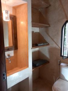 Un baño con inodoro, lavabo y espejo. en Clarisa villa, en Watamu