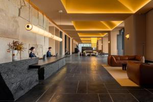 two people sitting at a reception desk in a lobby at Ascott Fengyishan Shenzhen in Shenzhen